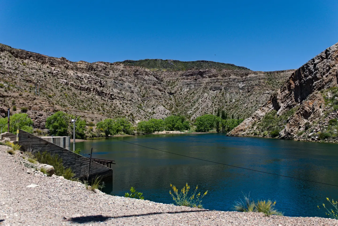 El Cañón del Atuel y un espejo de agua con sauces en la orilla