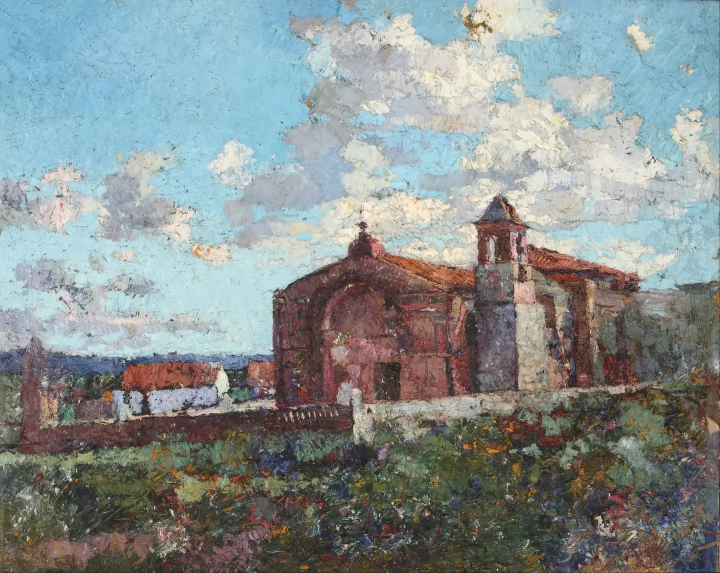 La capilla de Ischilín, de muros rojizos, bajo un cielo nublado